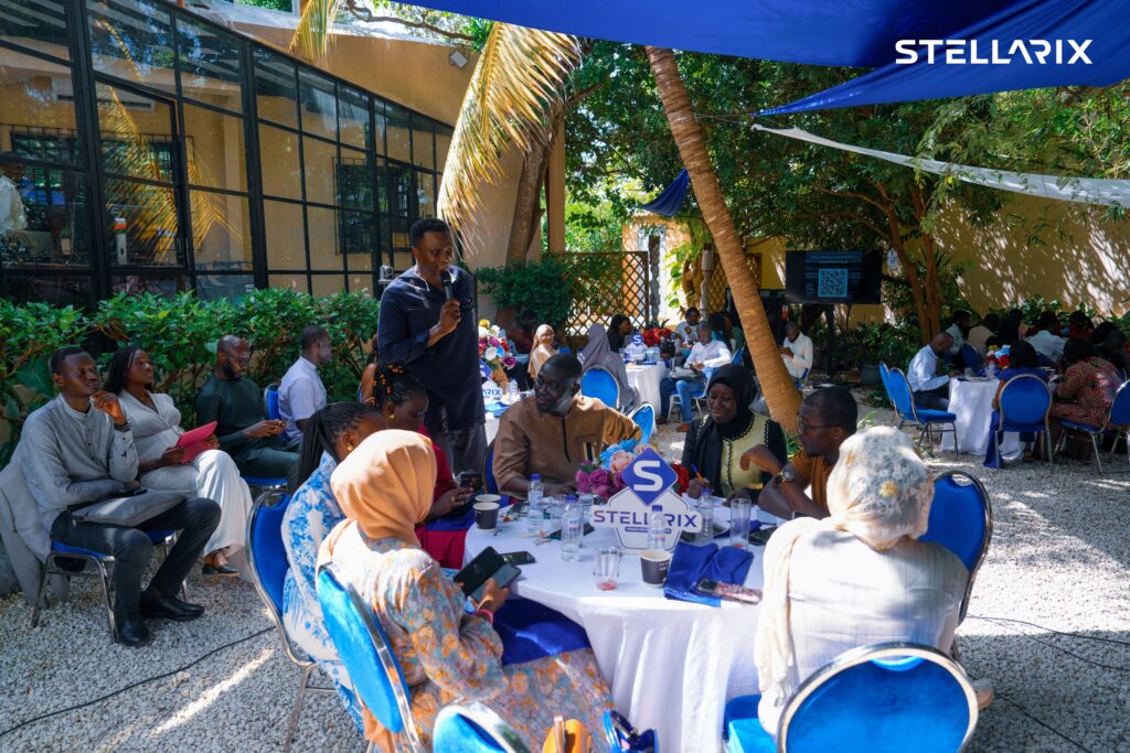 Participant au micro entouré de tables rondes en plein air lors du Business Breakfast STELLARIX Sénégal à Dakar